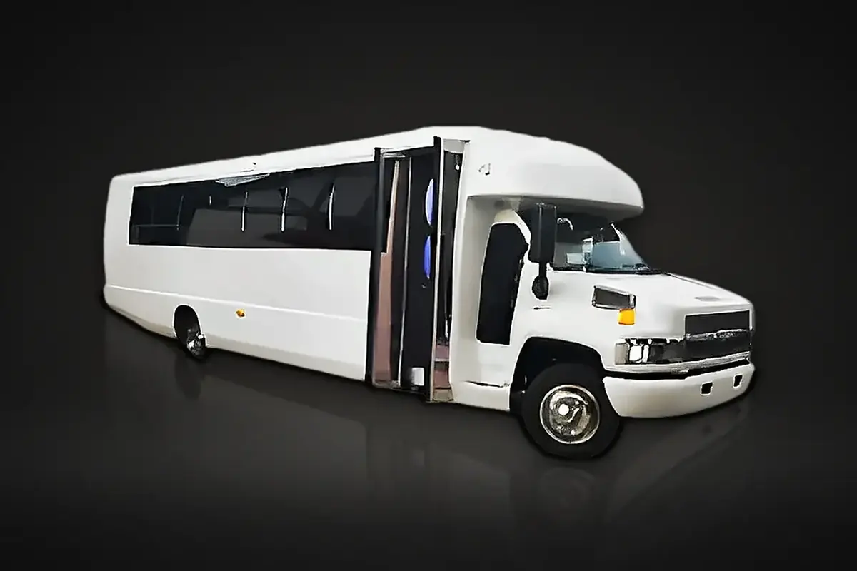 White party bus with the passenger door open outside a venue