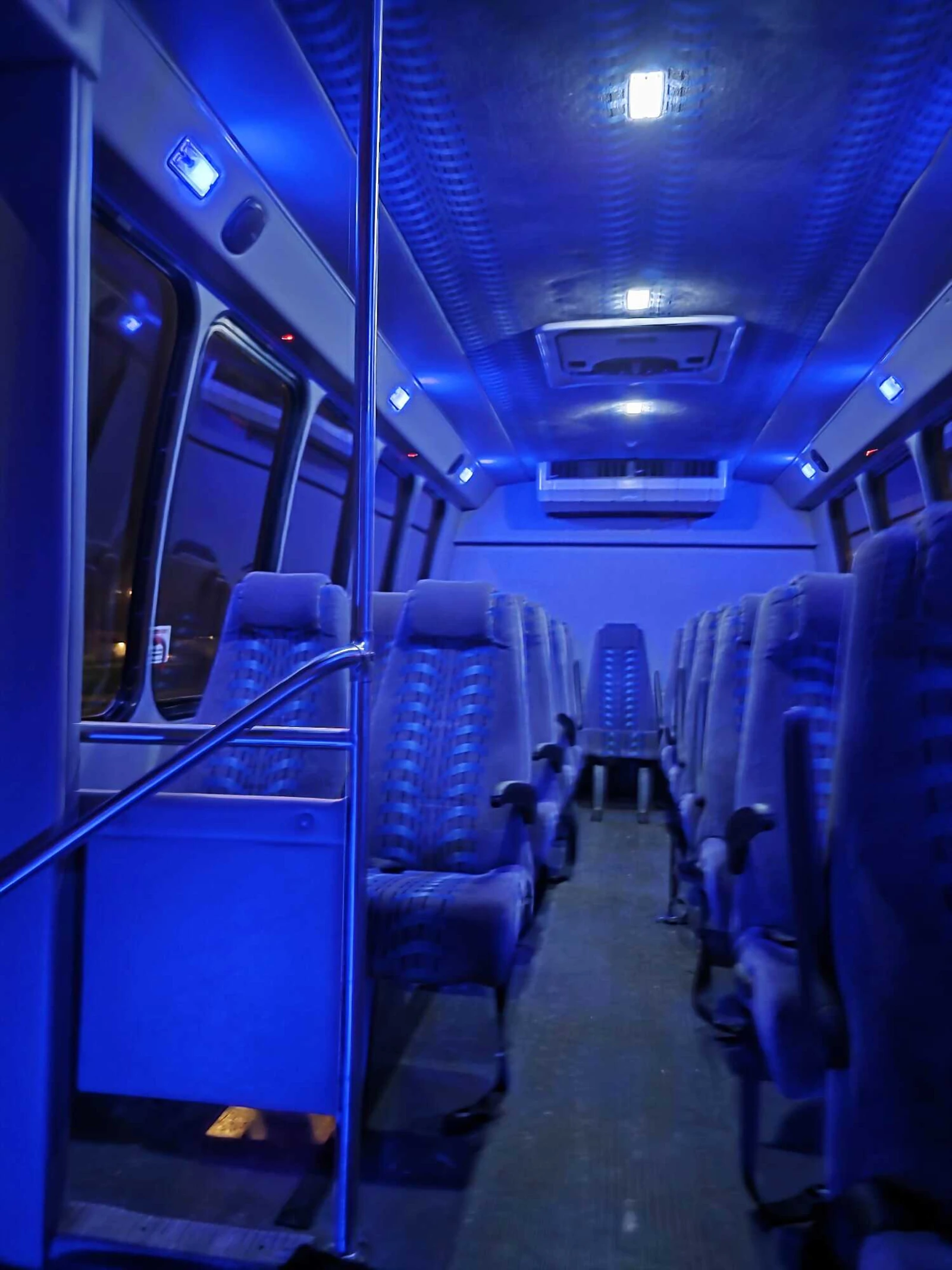 Mini bus interior with blue LED lighting and forward-facing seats