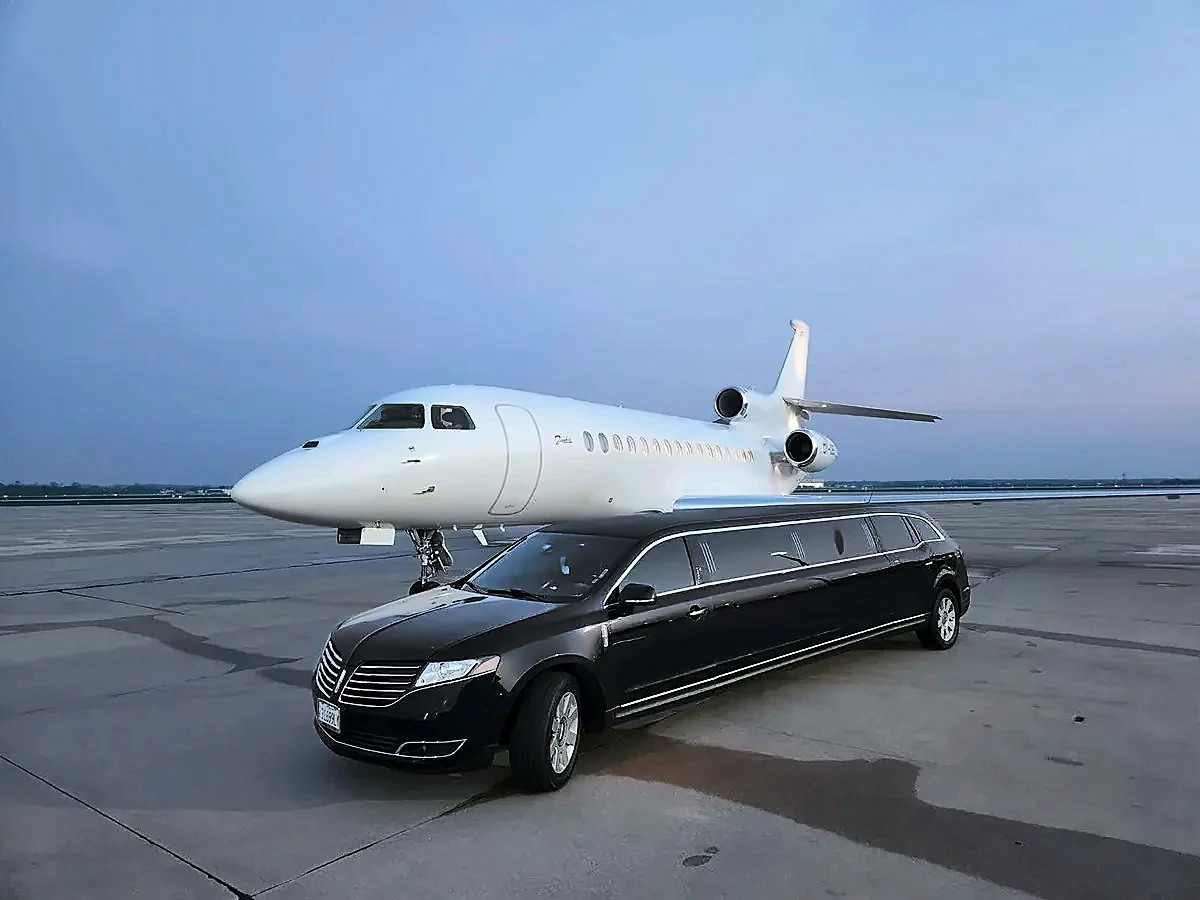Black Lincoln MKT stretch limousine beside a private jet on the tarmac